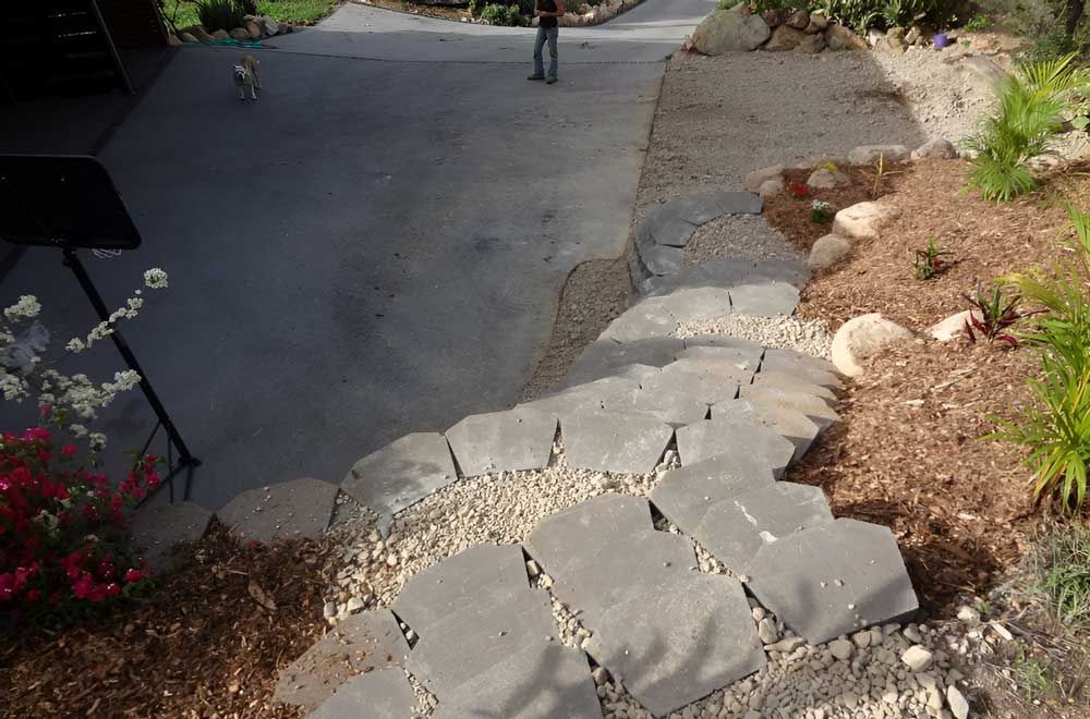 A Stone Walkway Leading To A Driveway — Austen Landscaping & Earthmoving in Deeragun, QLD