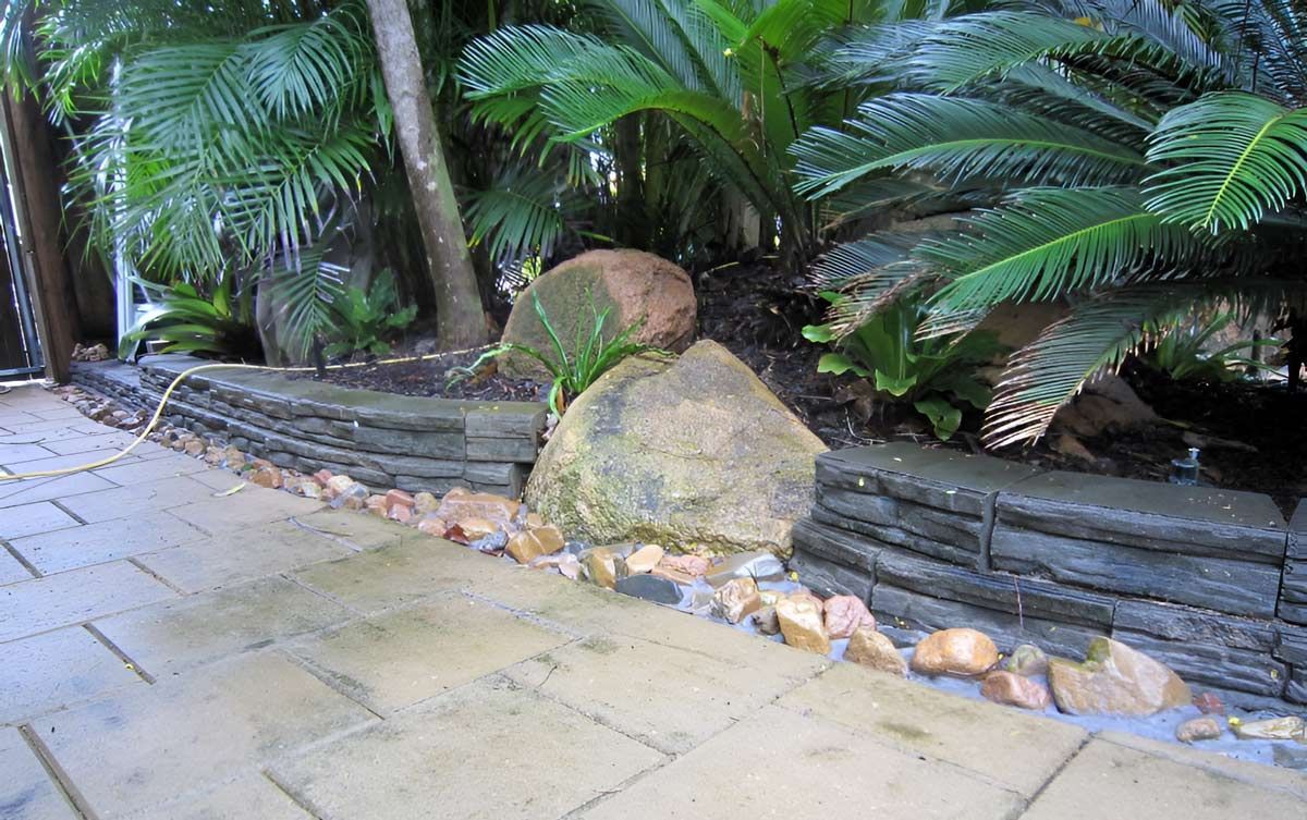 Walkway Is Surrounded By Palm Trees And Rocks — Austen Landscaping & Earthmoving in Deeragun, QLD