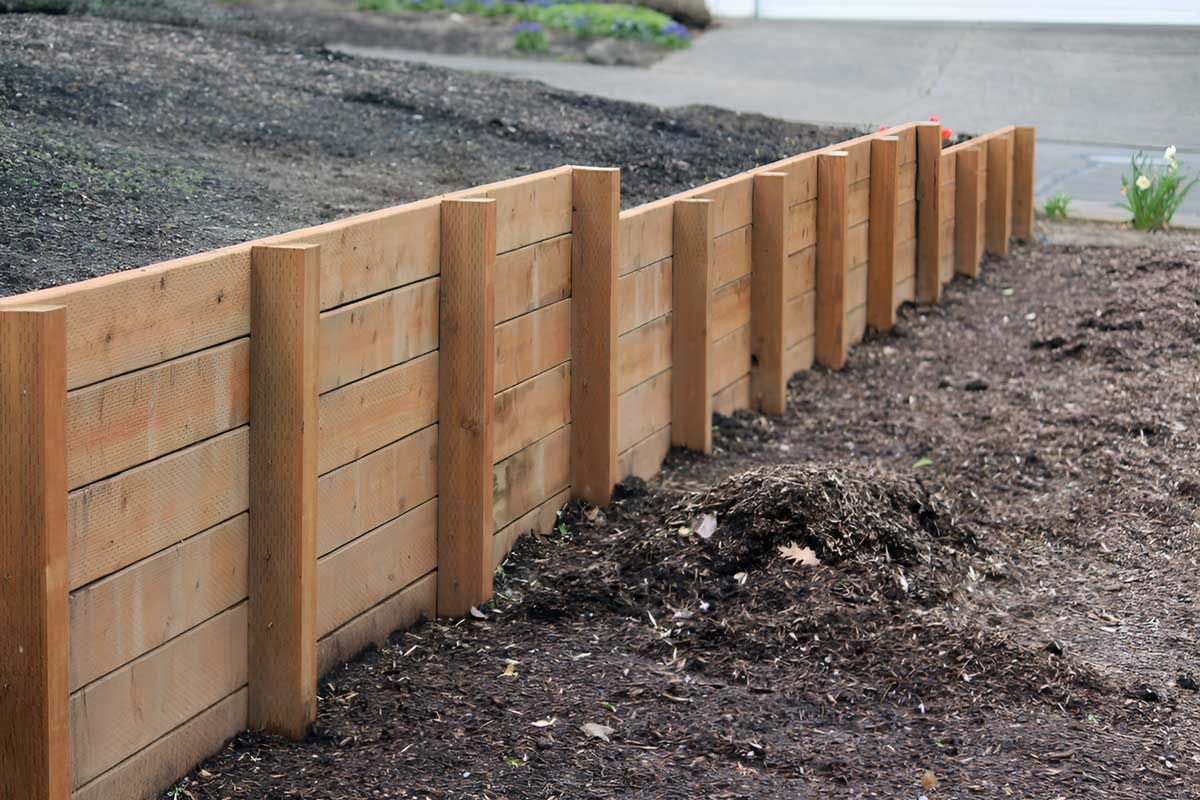 A Wooden Retaining Wall Fence — Austen Landscaping & Earthmoving in Deeragun, QLD