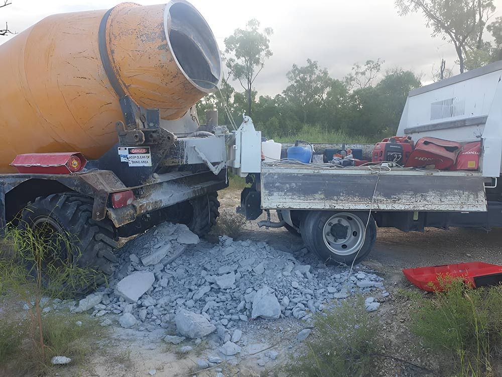 A Concrete Mixer Is Pouring Concrete Into A Truck — Austen Landscaping & Earthmoving in Ayr, QLD