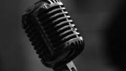 Close-up of a vintage black microphone against a dark background