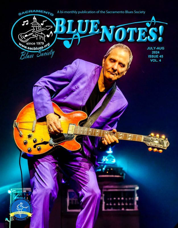 Man in a purple suit playing a yellow electric guitar on a neon-lit stage, with “Blue Notes!” text.