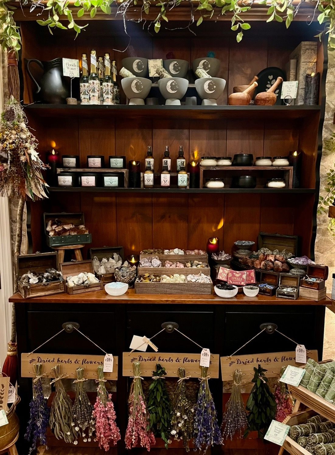 A shelf filled with candles and dried flowers in a store.