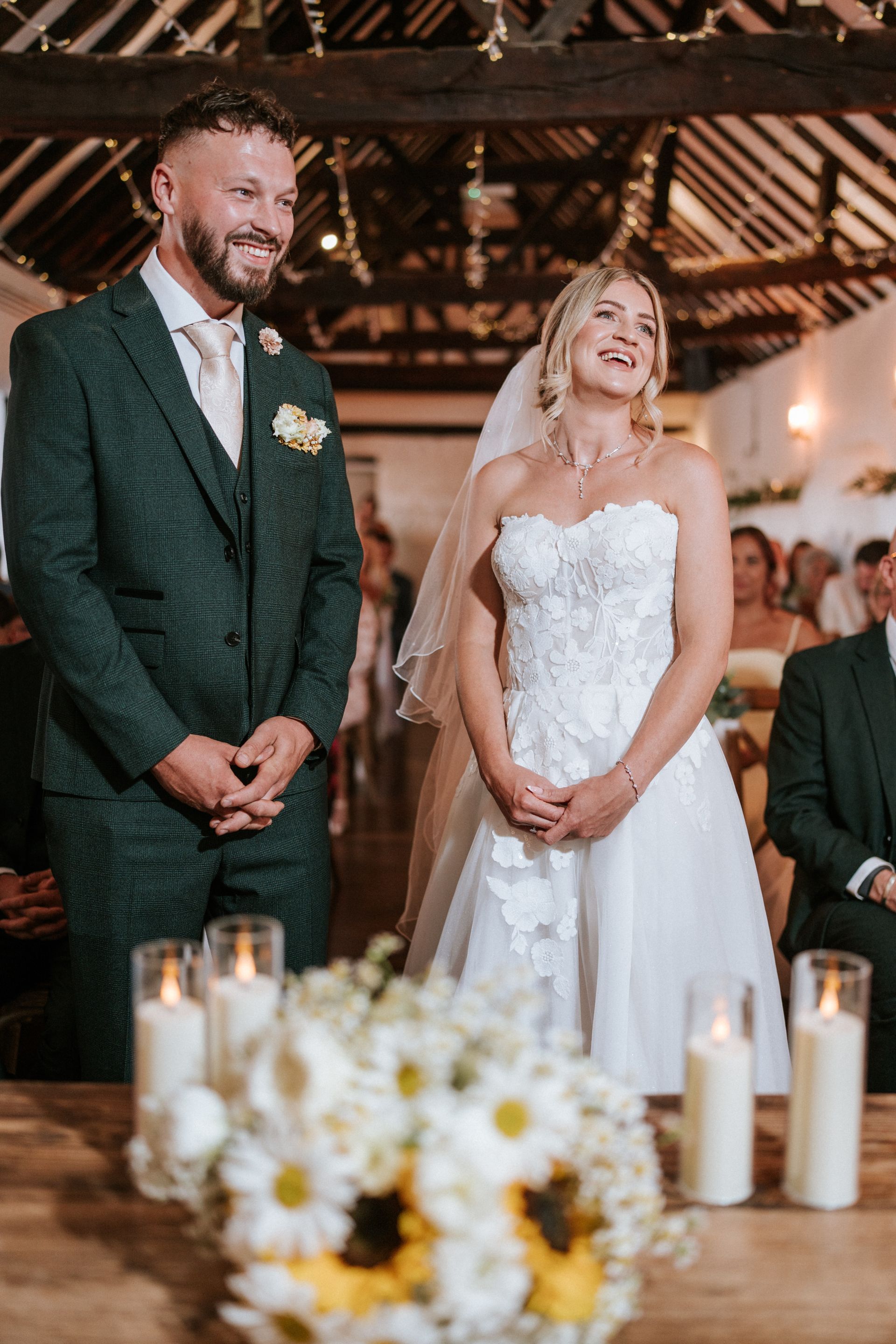 Bride and groom standing at the altar in a rustic barn wedding ceremony
