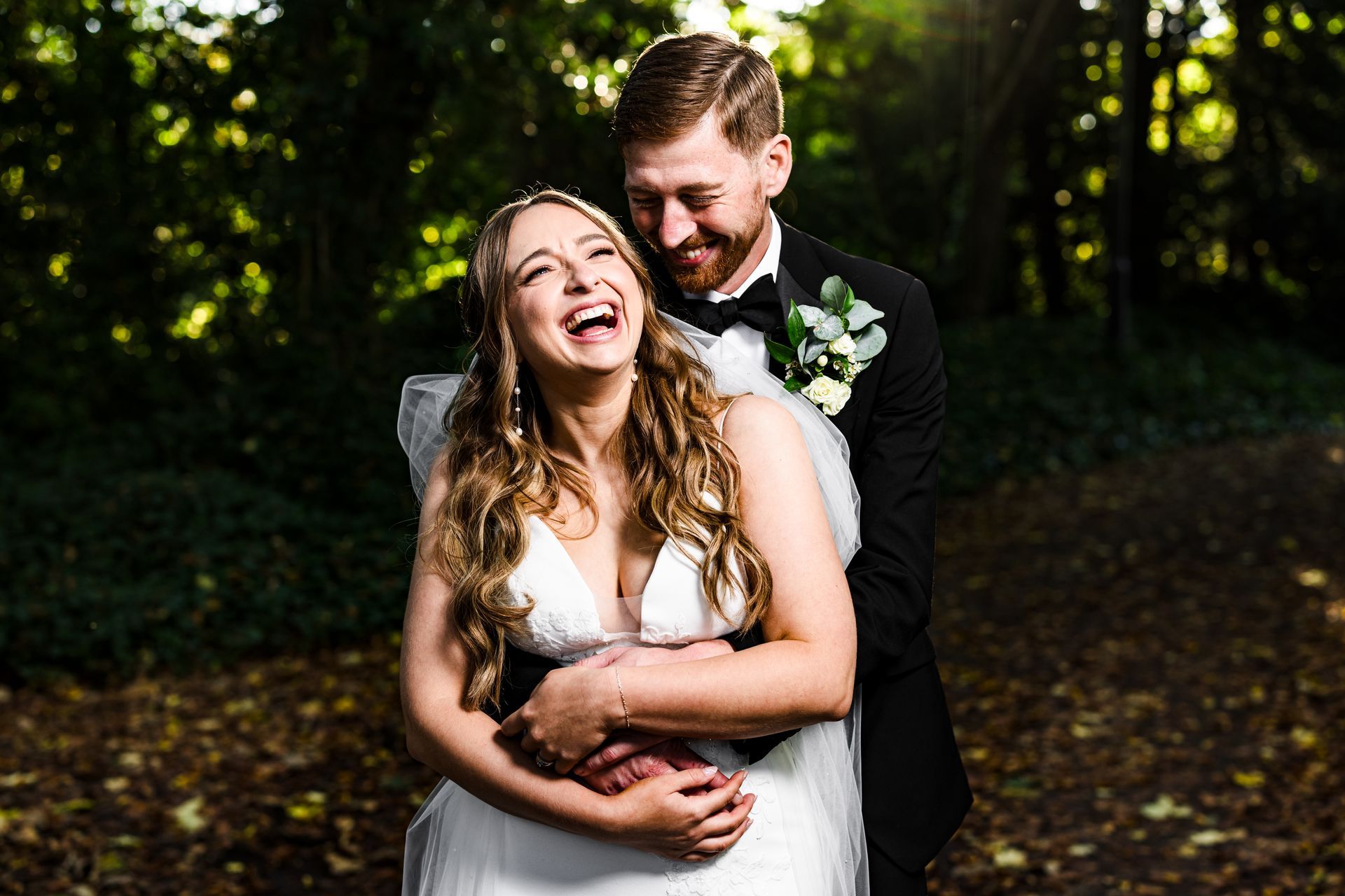 Bride and groom walking through a golden field at sunset