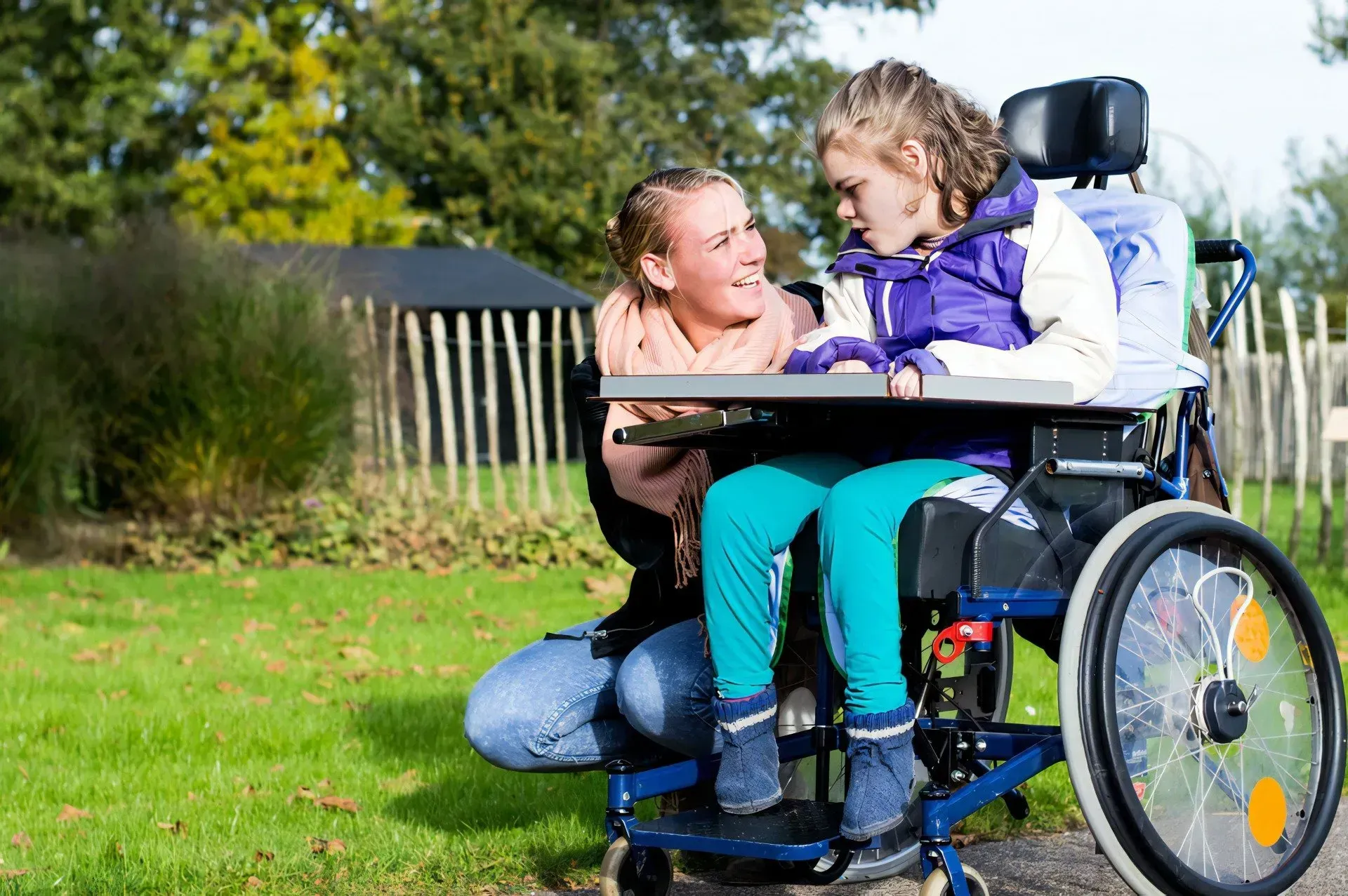 Caregiver Kneels on Grass to Talk With a Child — CQ Home Care in Yeppoon, QLD