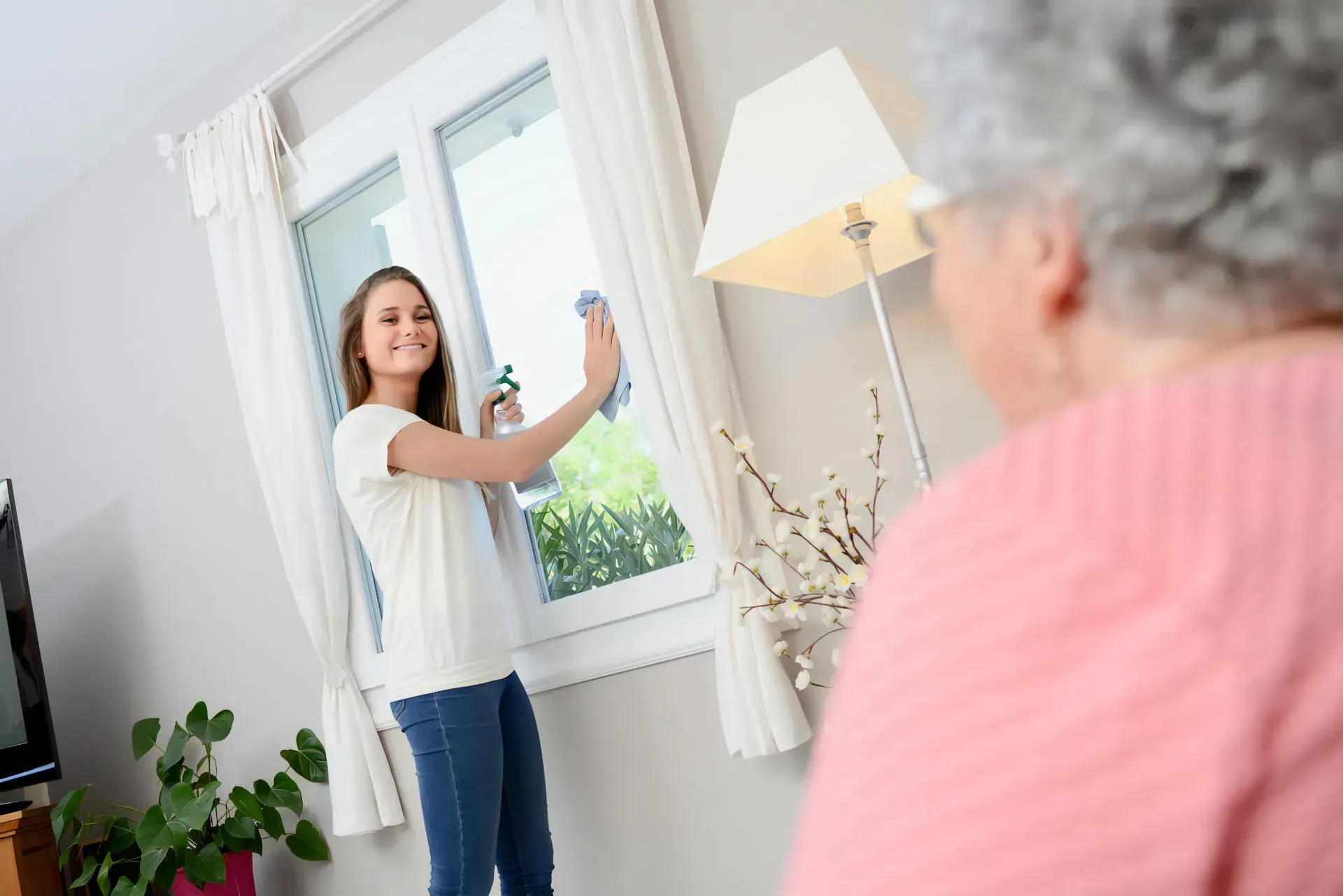 Person Cleans a Window in a Bright Room — CQ Home Care in Yeppoon, QLD