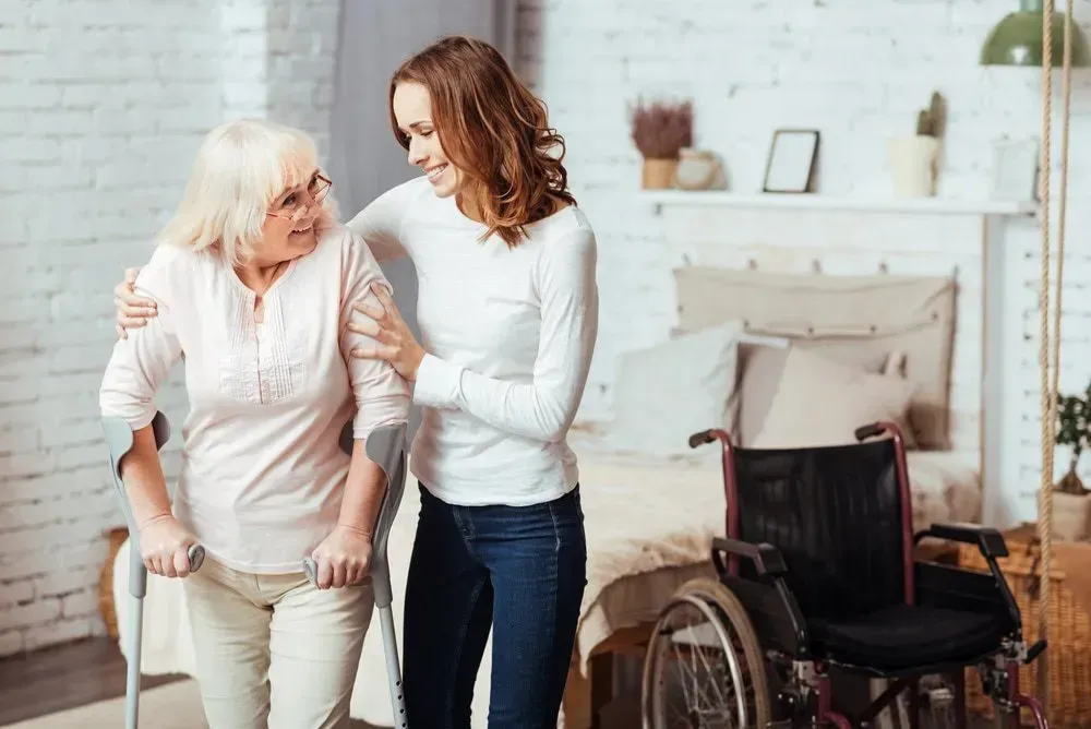 A Person Using Crutches for Support Walks With the Assistance of Another Person — CQ Home Care in Yeppoon, QLD