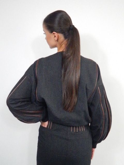 Woman in black jacket and mini skirt, with brown accents.