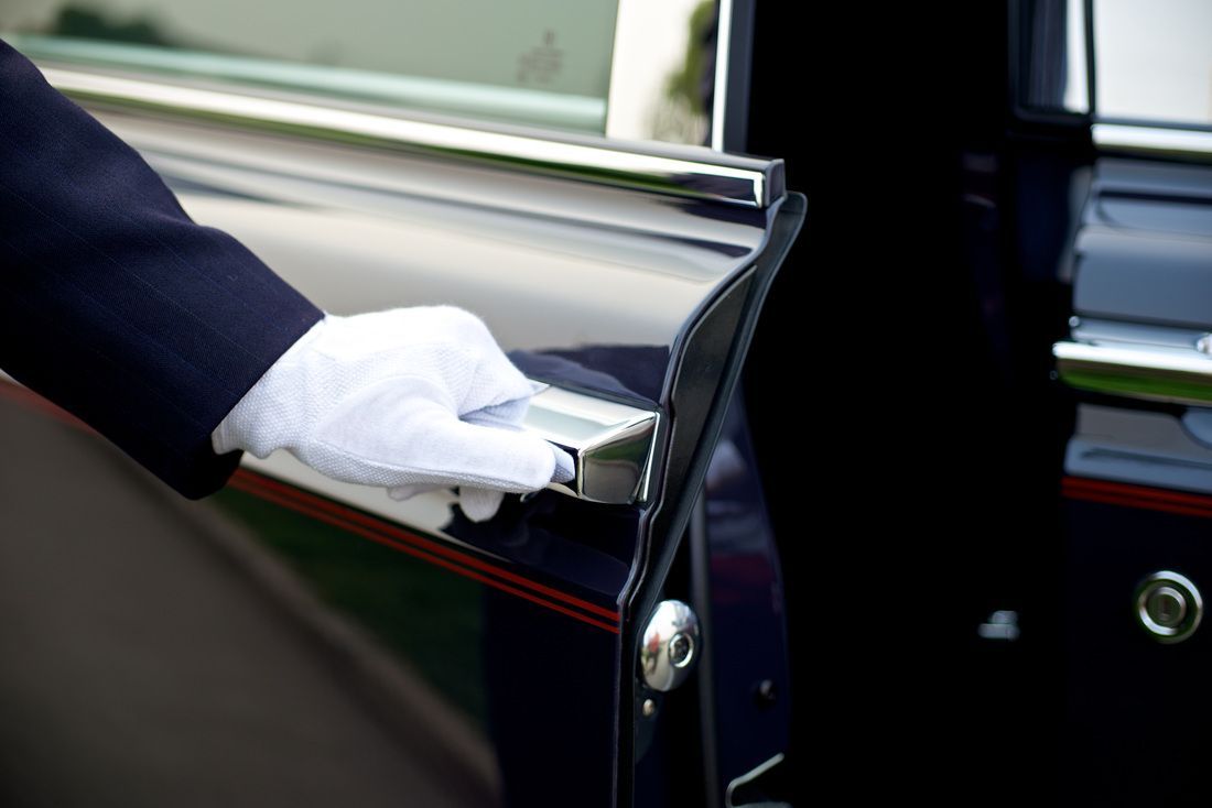 Luxury car service driver opening door