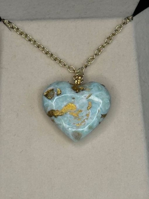 A necklace with a heart shaped pendant on a chain
