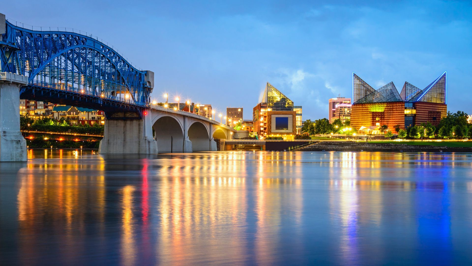 A bridge over a body of water with a city in the background.