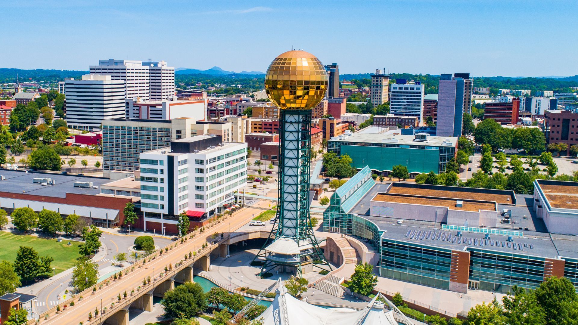 An aerial view of a city with a clock tower in the middle of it.