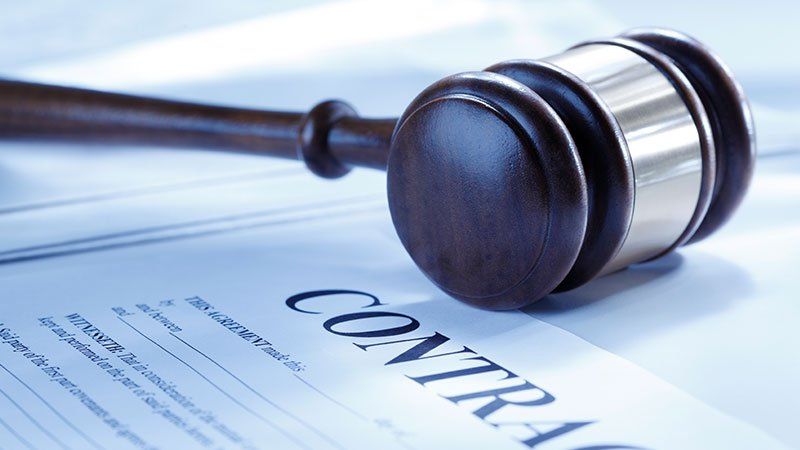 gavel lying on contract paper