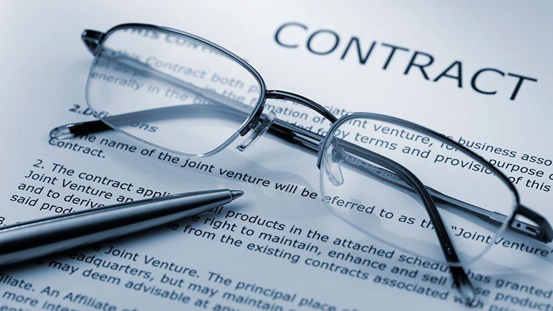 glasses and pen lying on contract paper