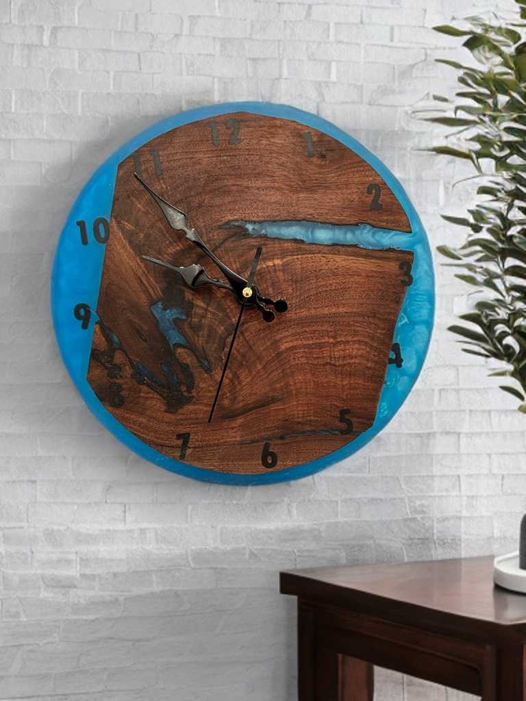 Wood and blue resin clock on a white brick wall. Brown wood center, black hands, black numerals.