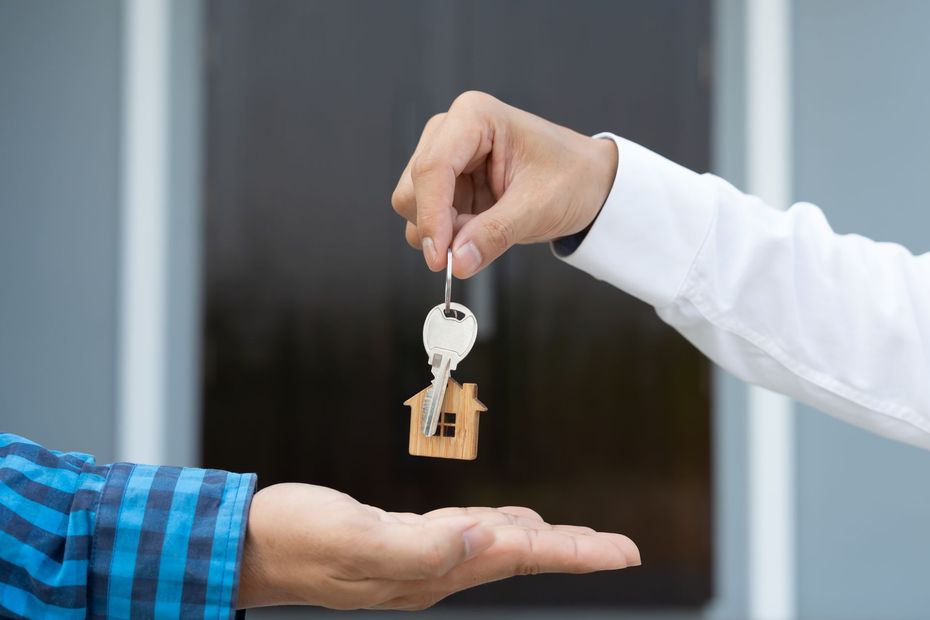 Hand over of house keys from one person to another over an outstretched palm