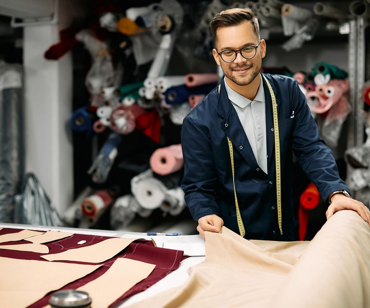 Tailor Using Fabric Roll While Working at Clothing Workshop — Indianapolis, IN — Phoenix Design Concepts Tailor Using Fabric Roll While Working at Clothing Workshop — Indianapolis, IN — Phoenix Design Concepts