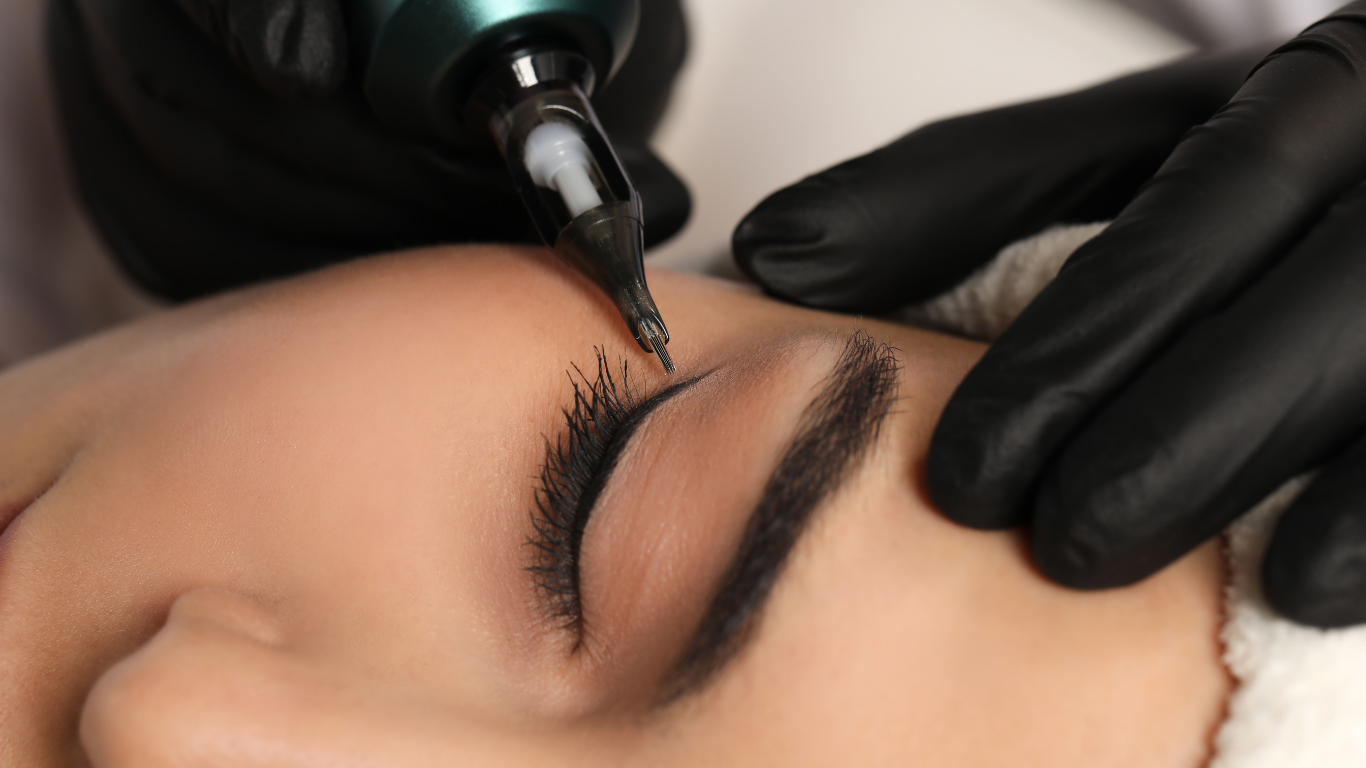Close-up of eyebrow tattooing with a microblading pen and gloved hands