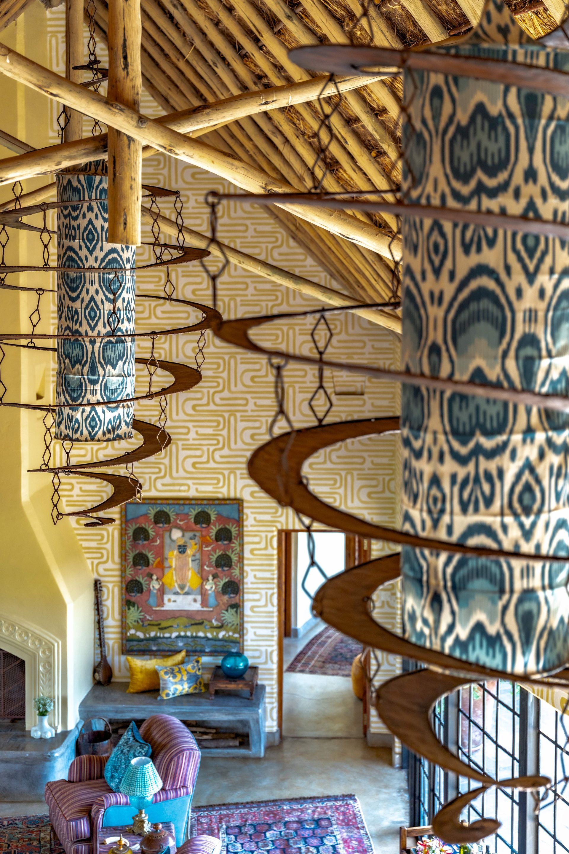 Decorated lodge interior with carved spiral staircase, painted columns, and patterned ceiling