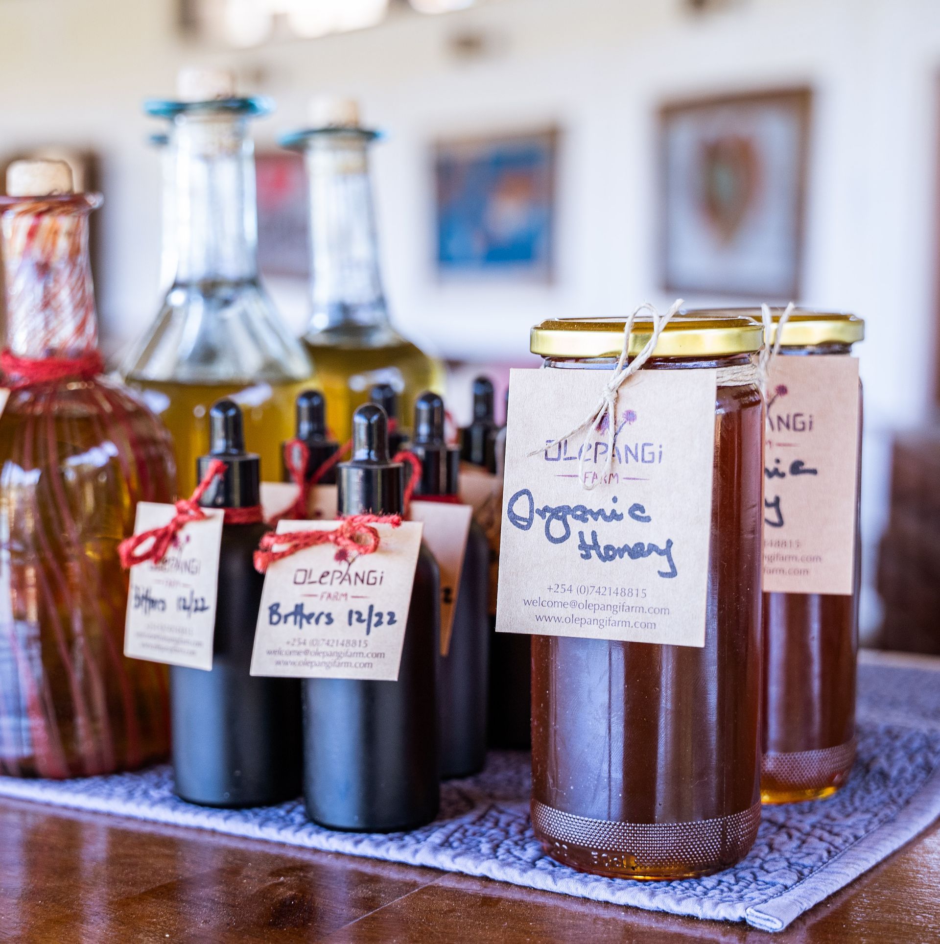 Assorted homemade bottles and jars of amber and dark liquids on a table with handwritten labels