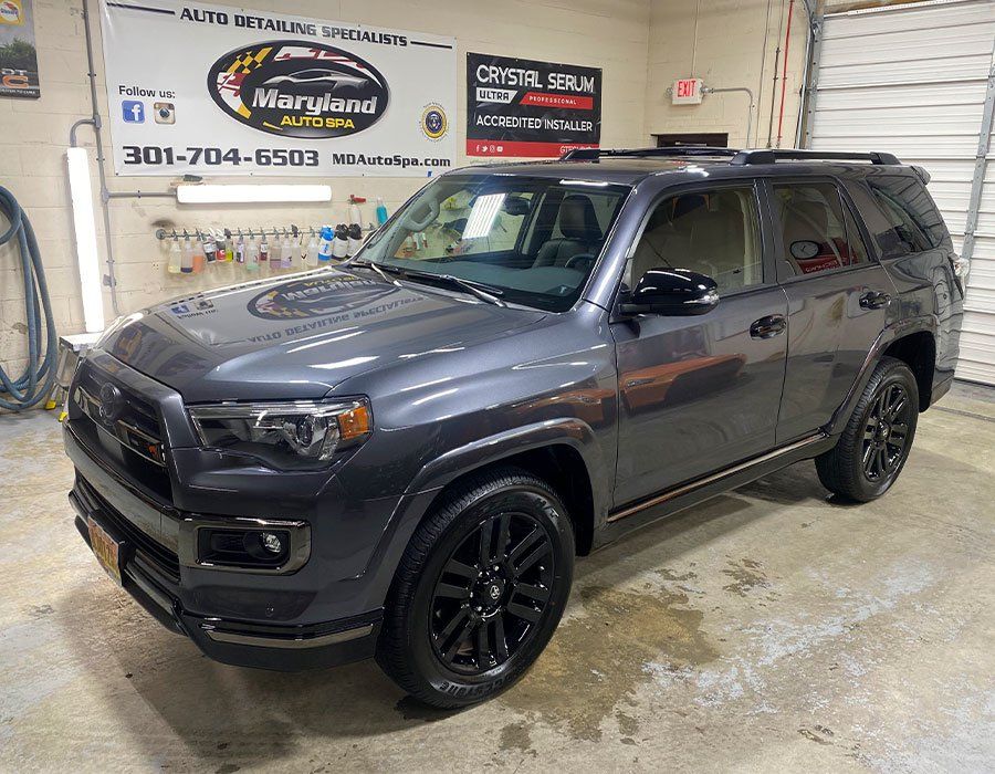 A gray toyota 4runner is parked in a garage.
