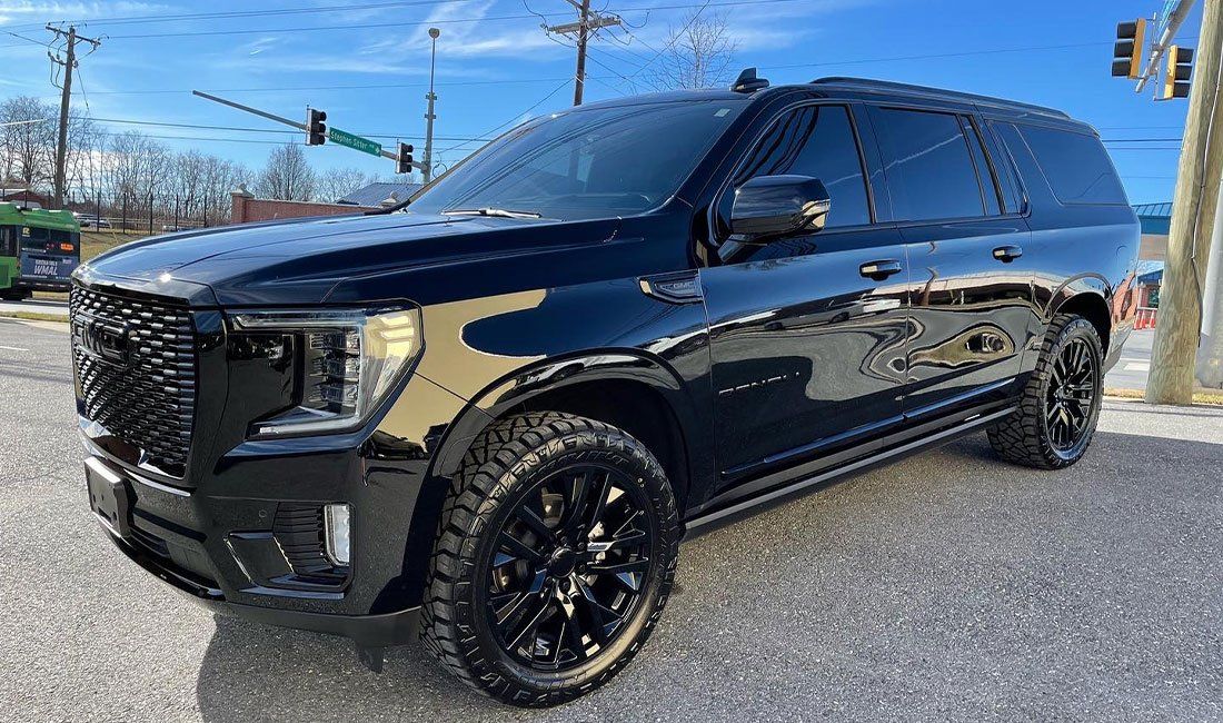 A black suv is parked on the side of the road.