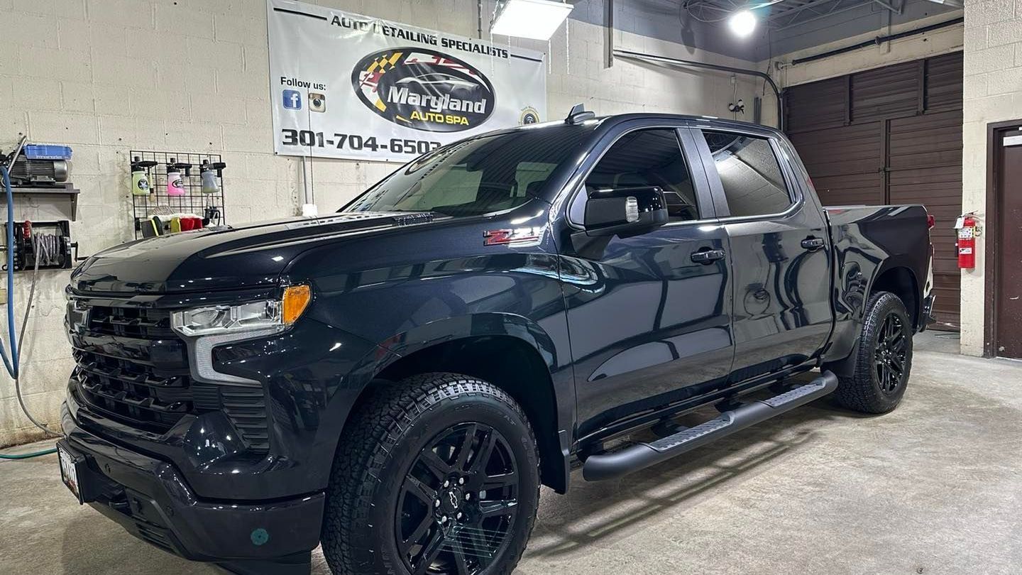 A black pickup truck is parked in a garage.