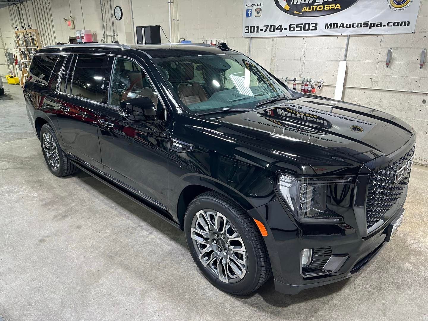 A black suv is parked in a garage.