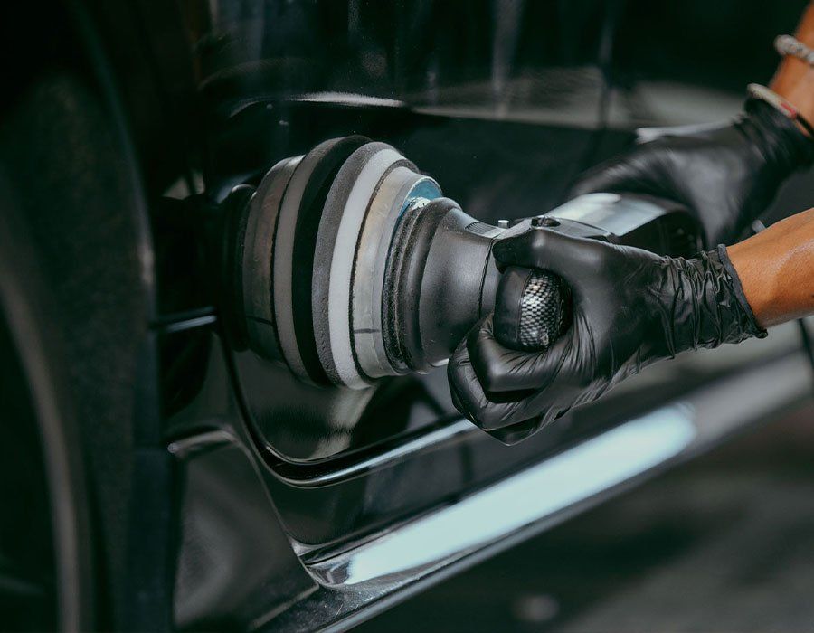 A person is polishing a car with a machine.