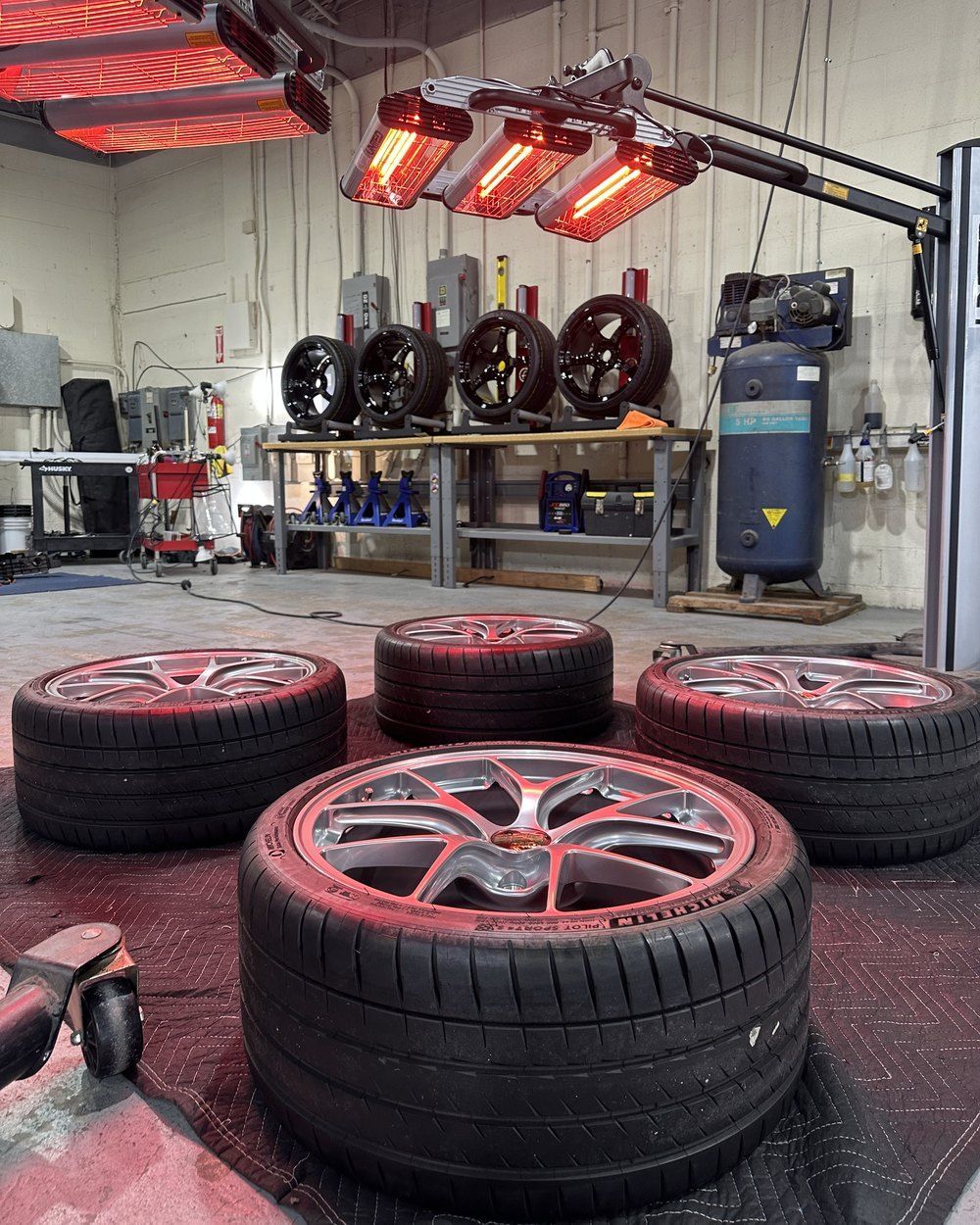 Wheels with a fresh ceramic coating curing under infrared lamps at Maryland Auto Spa in Silver Spring, MD