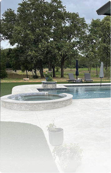 Backyard pool with circular spa, lounge chairs, and large tree by a grassy lawn