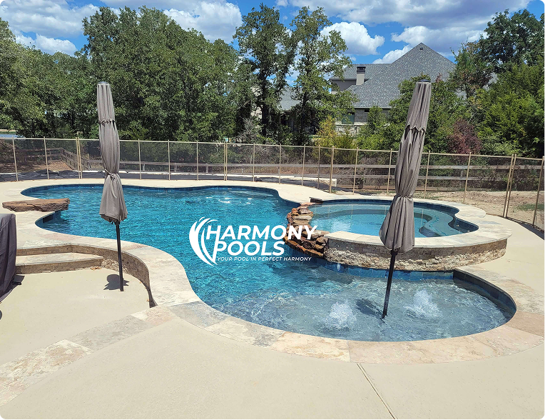 Backyard swimming pool with blue water, stone deck, and closed patio umbrellas under a sunny sky