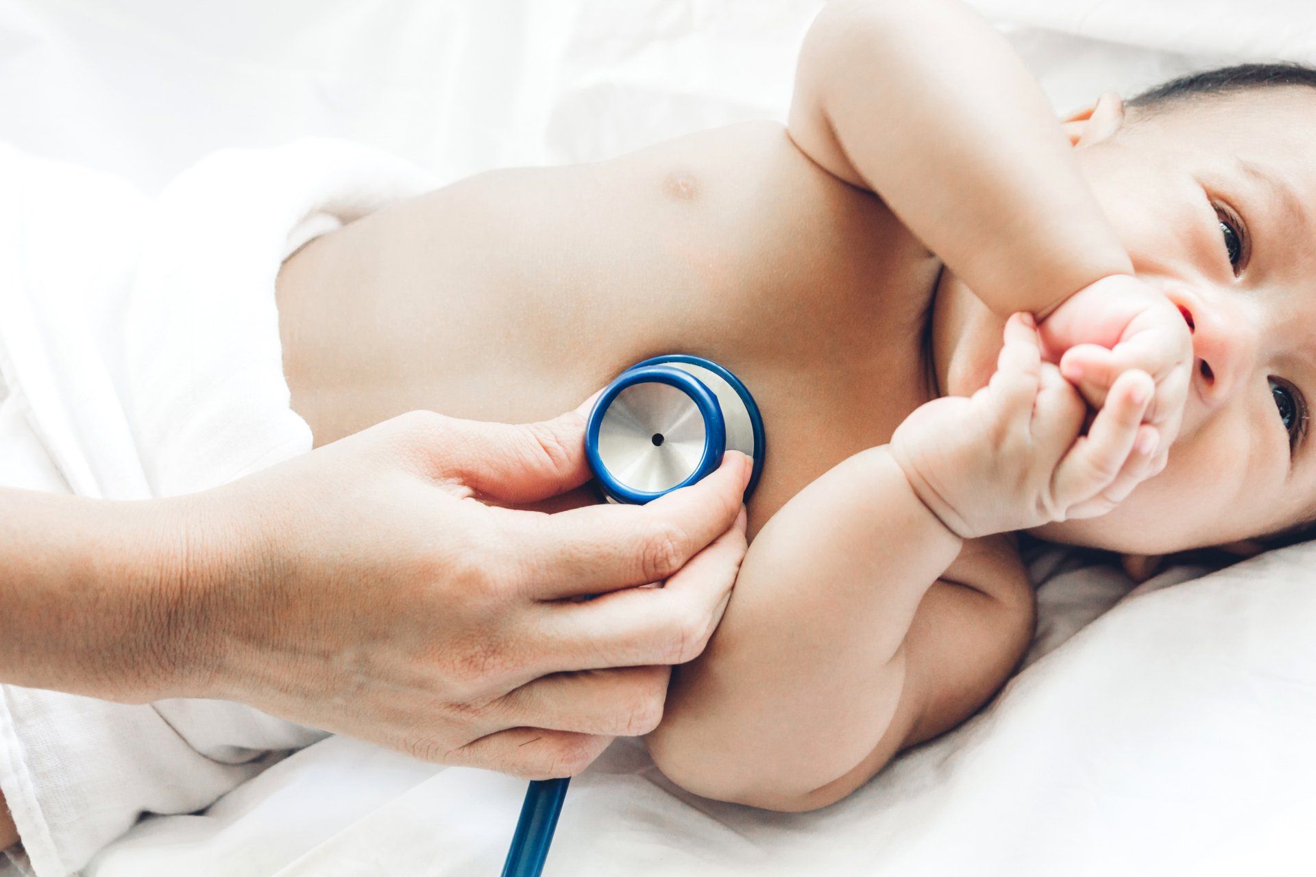 A baby is being examined by a doctor with a stethoscope.