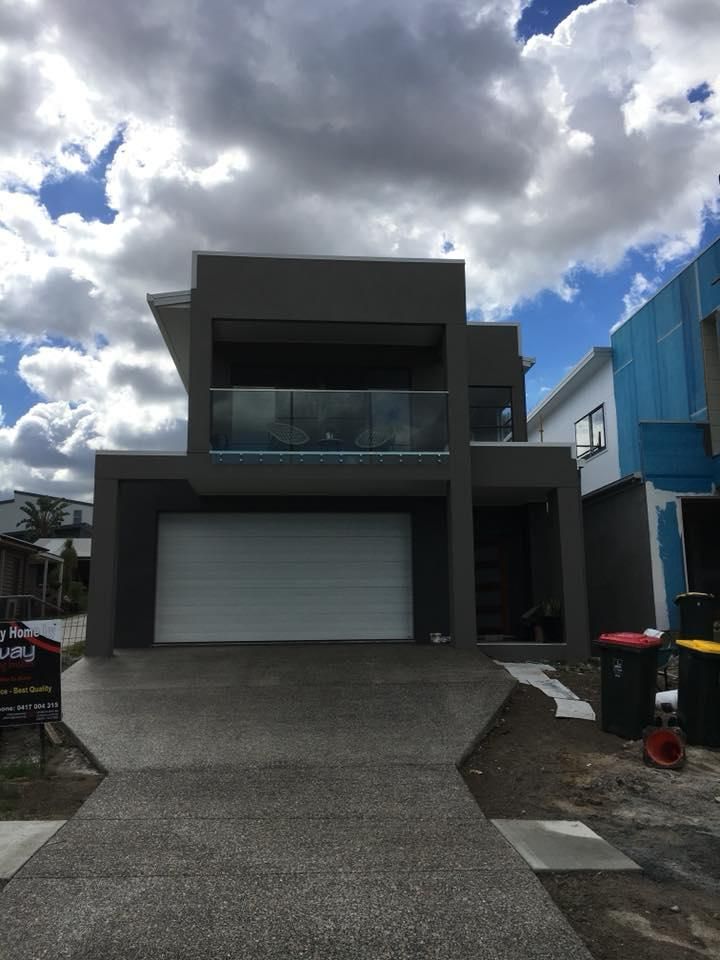 A Large House with A White Garage Door and A Balcony — Polson Construction in Kedron, QLD