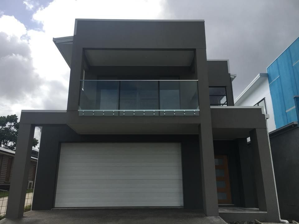 A House with A White Garage Door and A Balcony — Polson Construction in Kedron, QLD