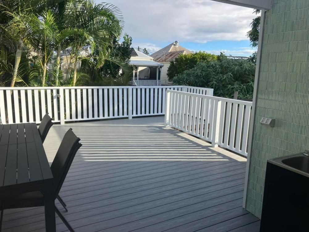 A Deck with A Table and Chairs and A White Railing — Polson Construction in Kedron, QLD