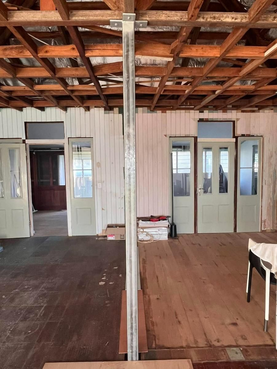 A Room with A Wooden Floor and A Metal Pole in The Middle — Polson Construction in Kedron, QLD