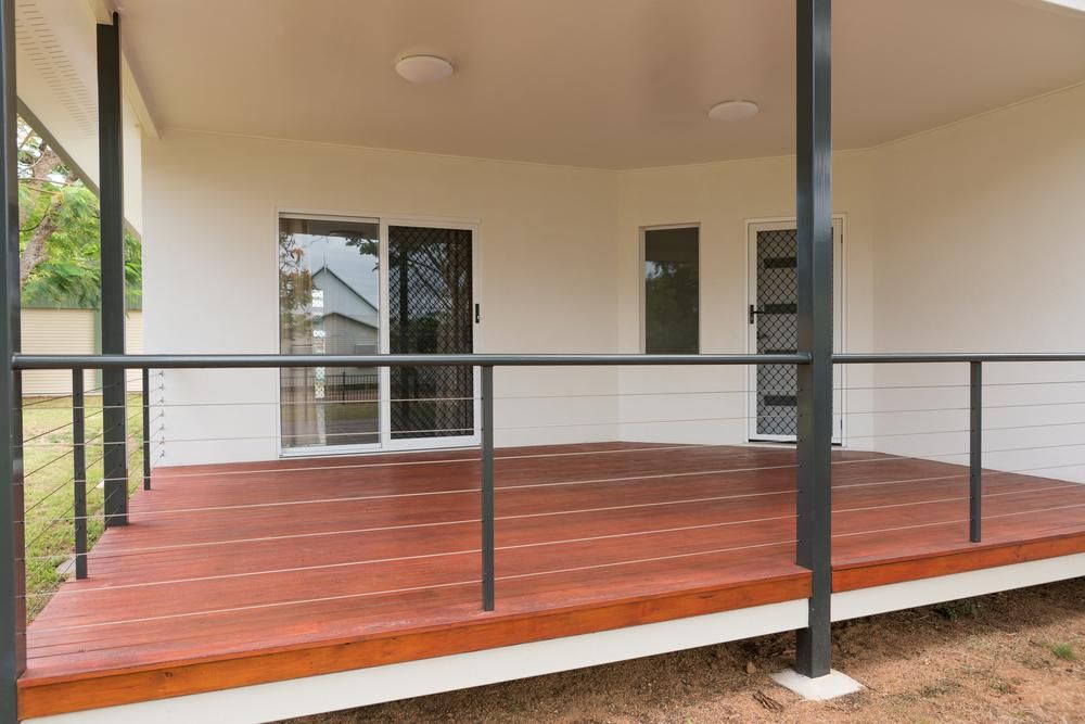 An Empty Porch with A Wooden Deck and A Metal Railing — Polson Construction in Brighton, QLD