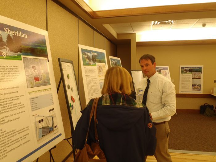 A man and a woman are looking at a poster that says shervin