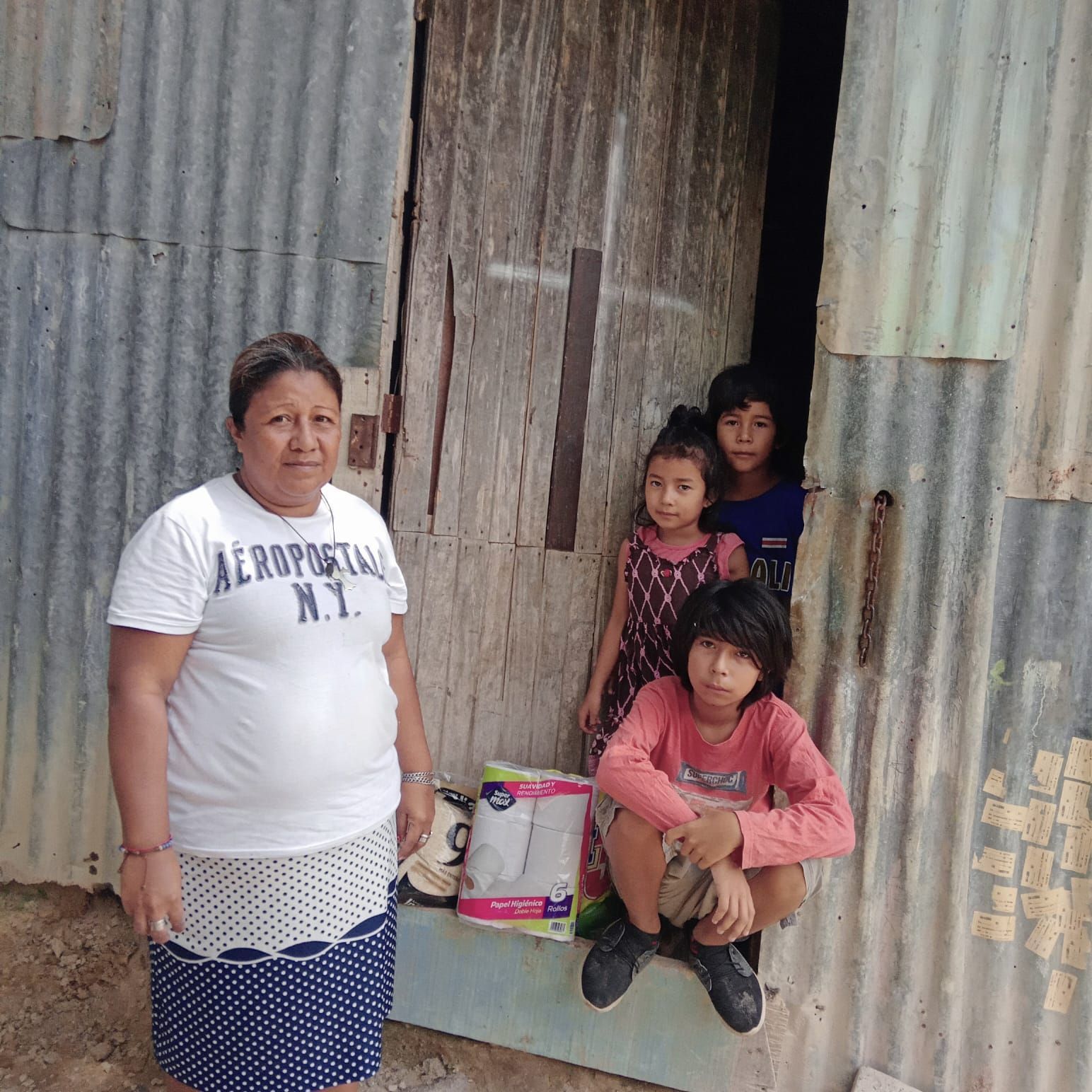 A woman wearing an aeropostale shirt stands next to three children