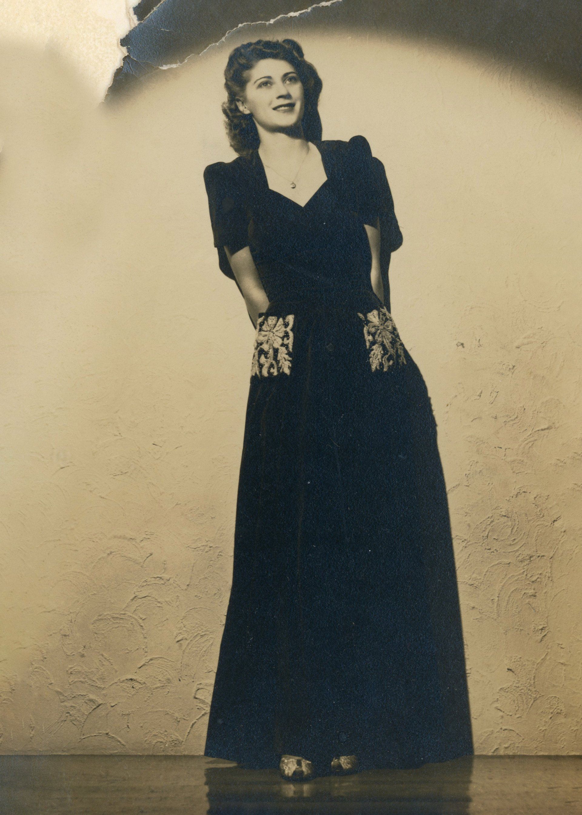 A black and white photo of a woman in a long black dress