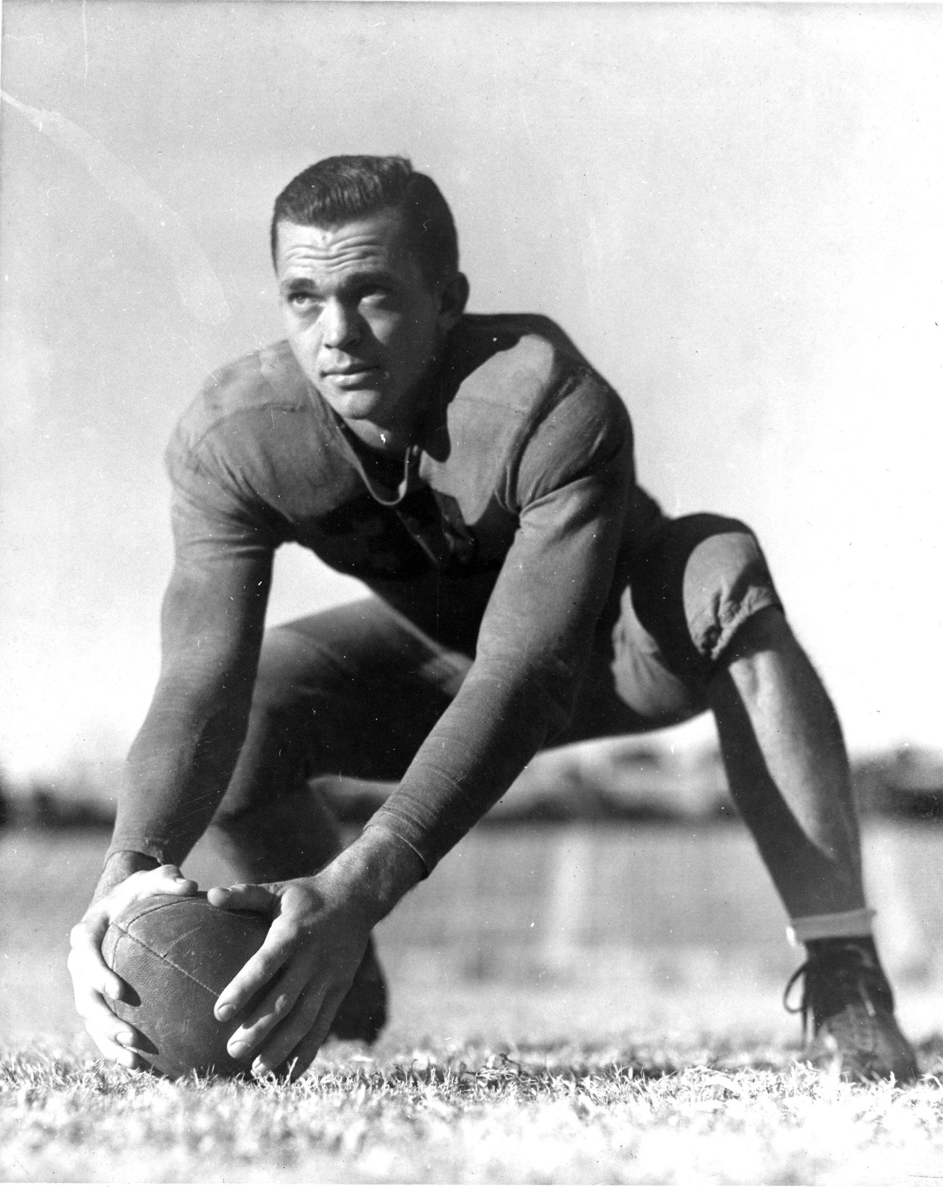 A black and white photo of a man holding a football