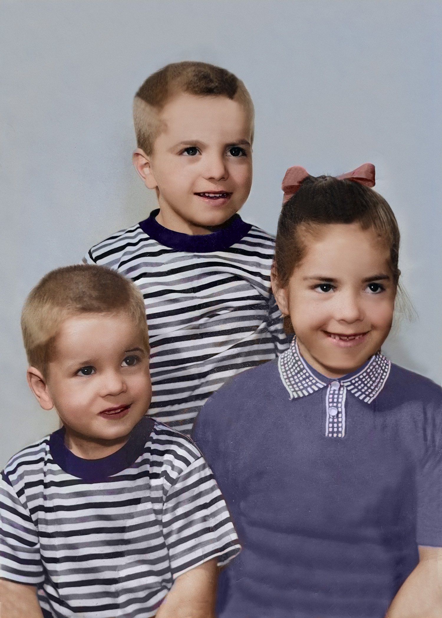 Two boys and a girl are posing for a picture