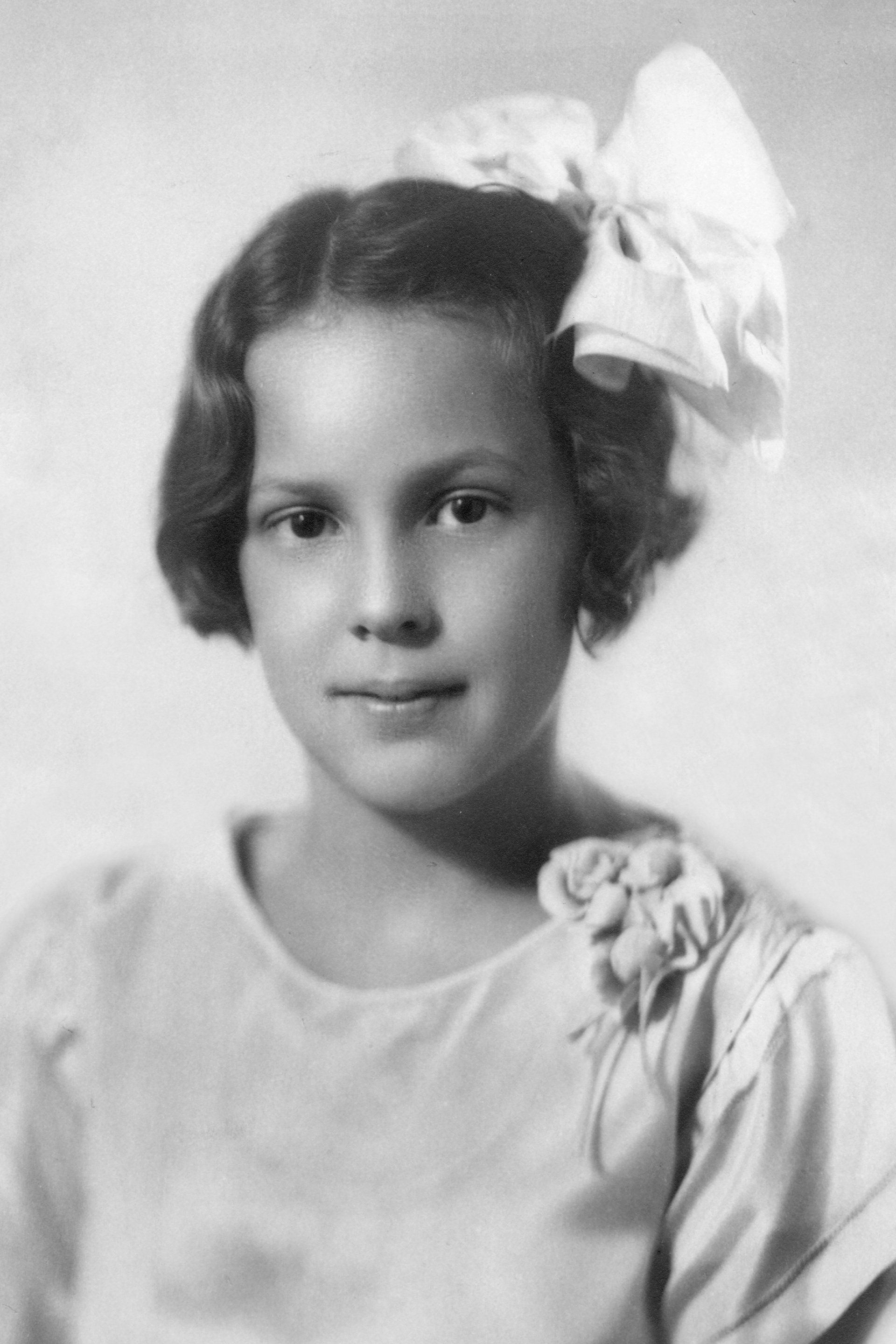 A little girl with a white bow in her hair
