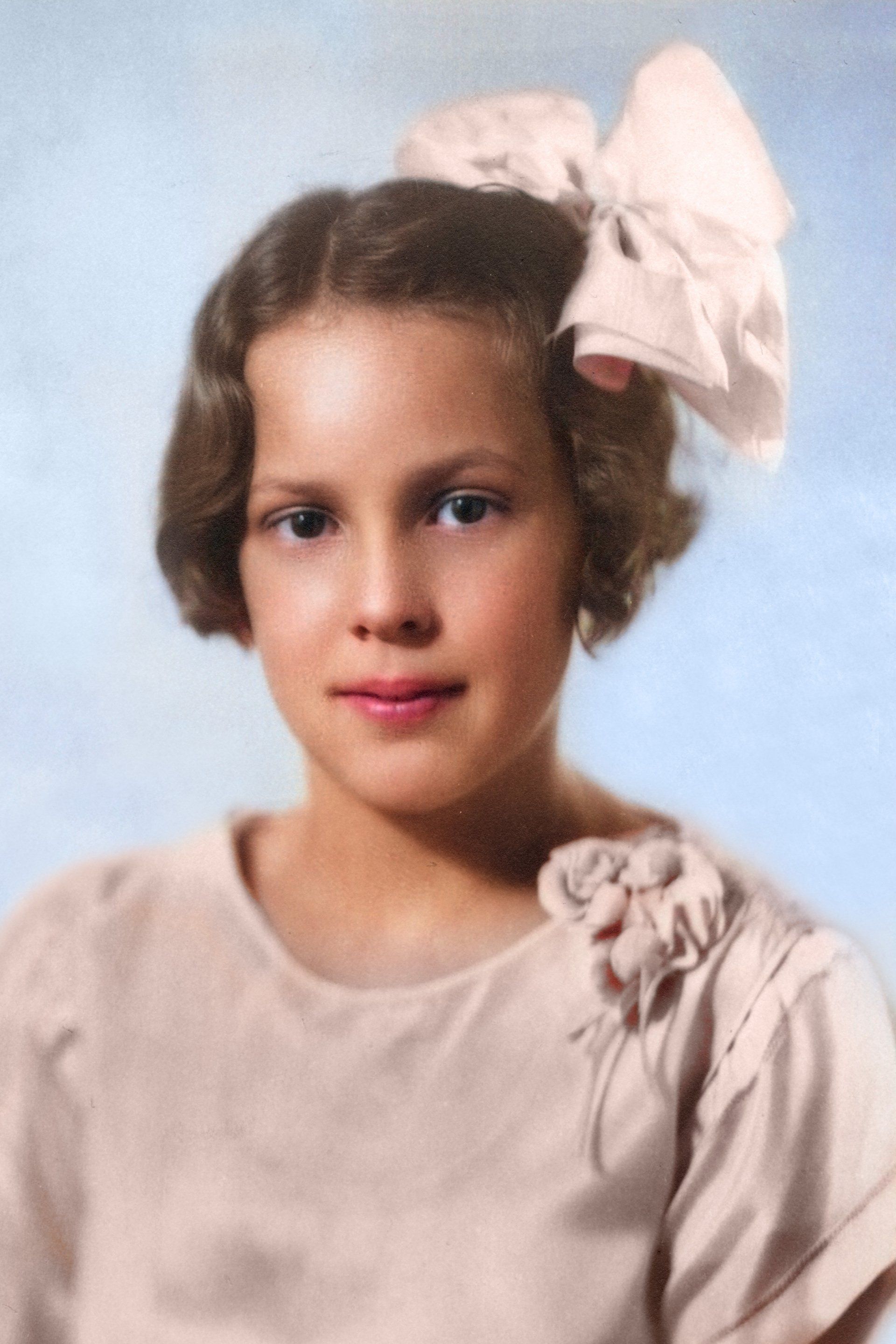 A young girl with a pink bow in her hair