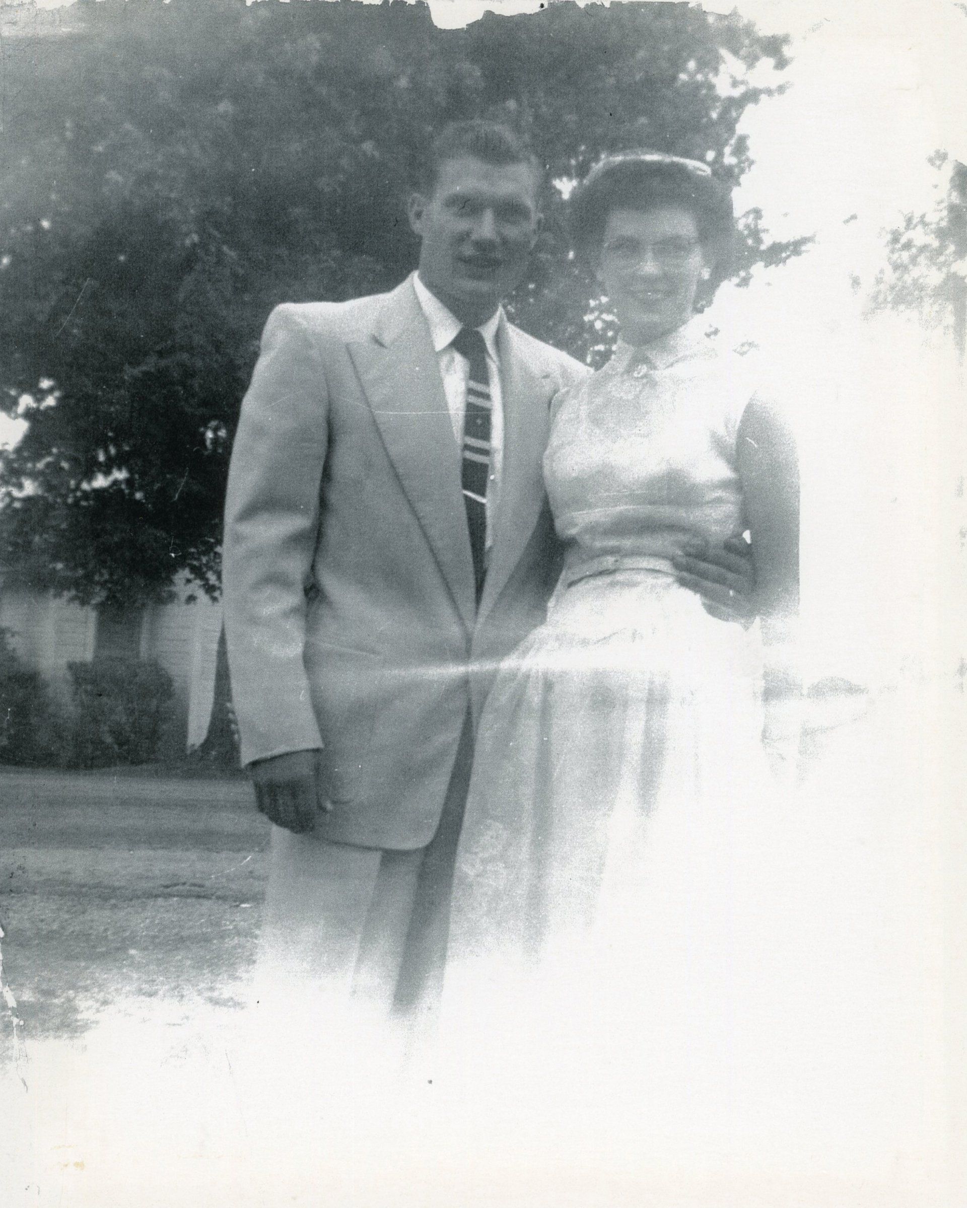 A black and white photo of a man and woman standing next to each other.