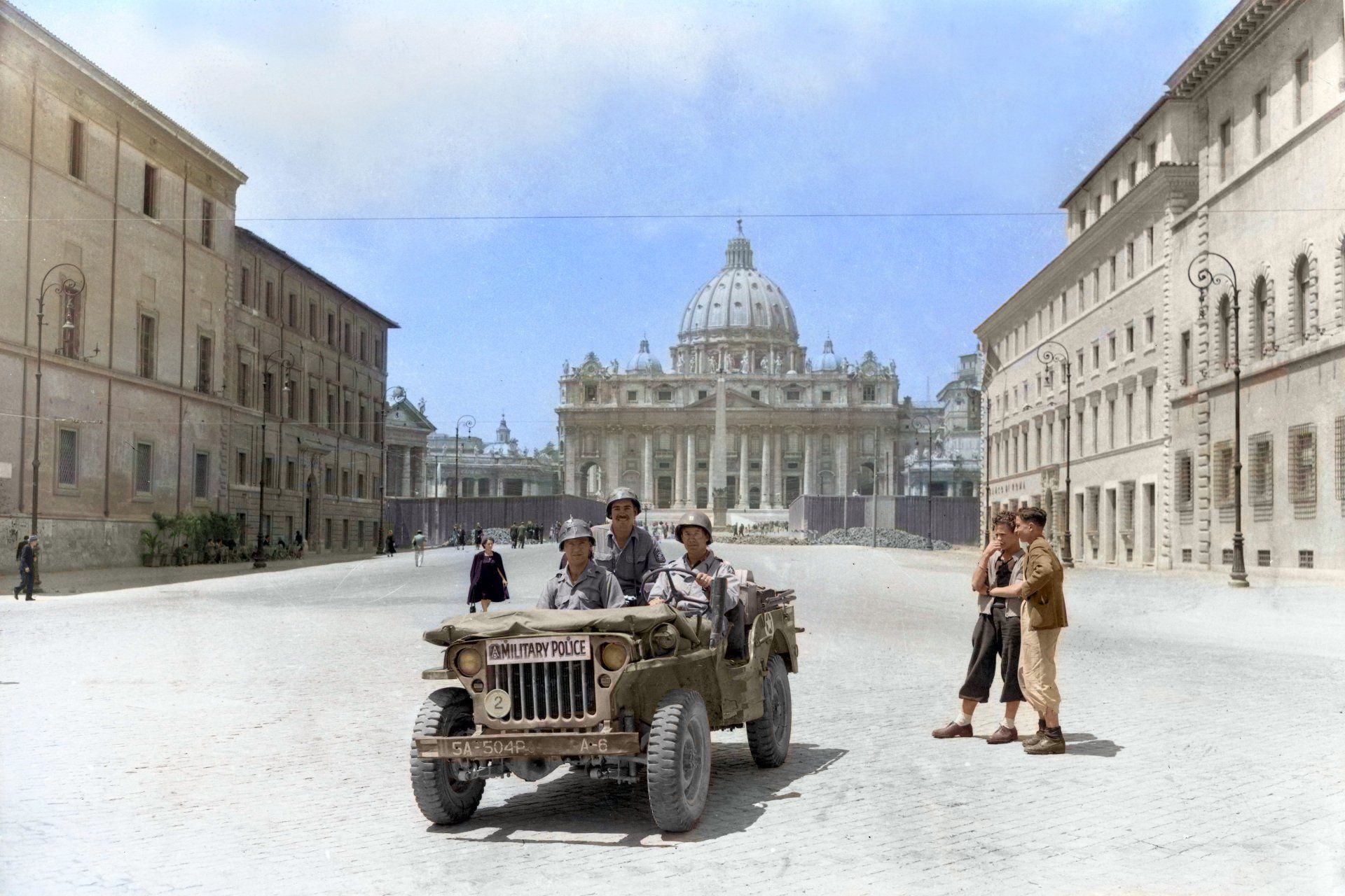 A jeep is driving down a street in front of a building