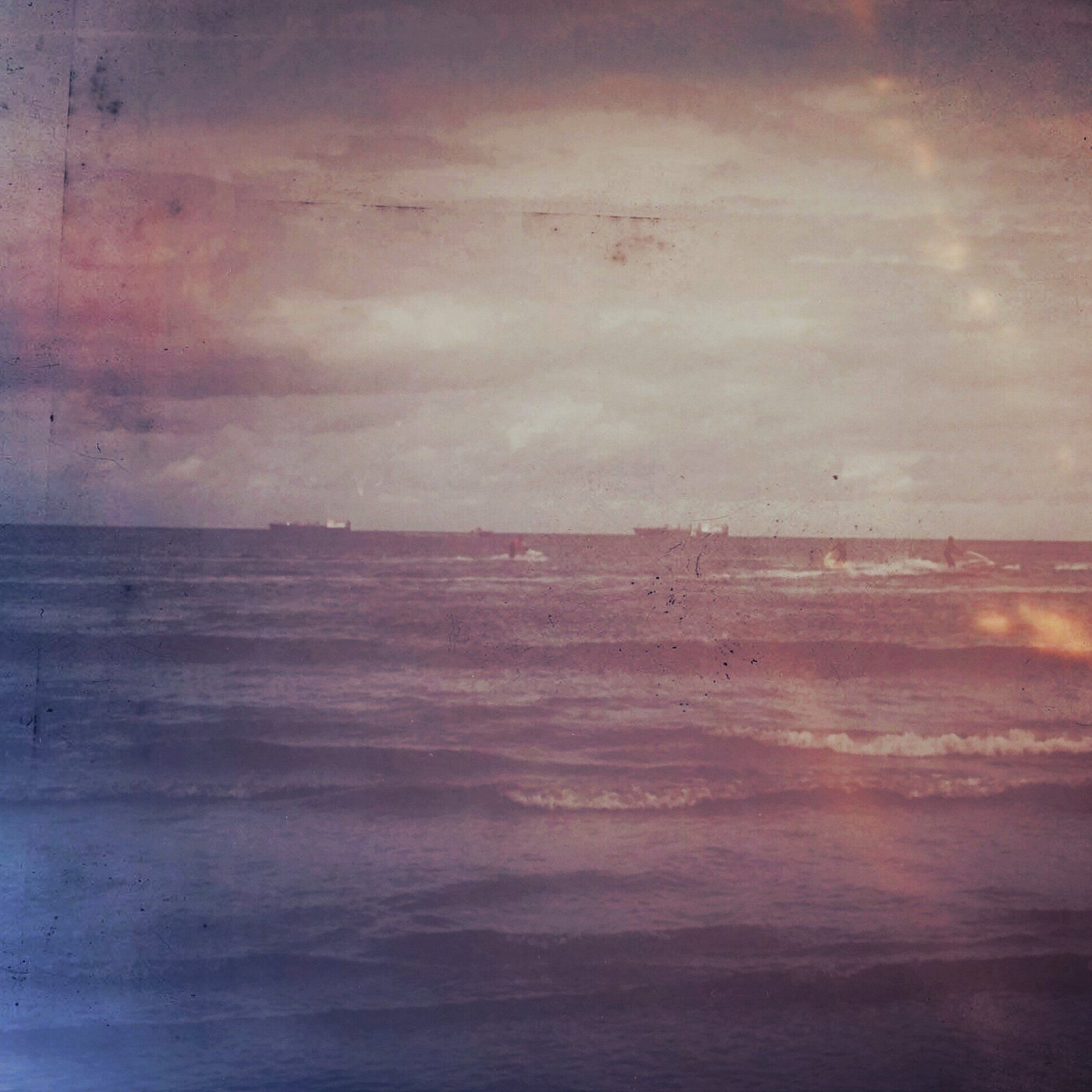 A painting of the ocean with boats in the distance
