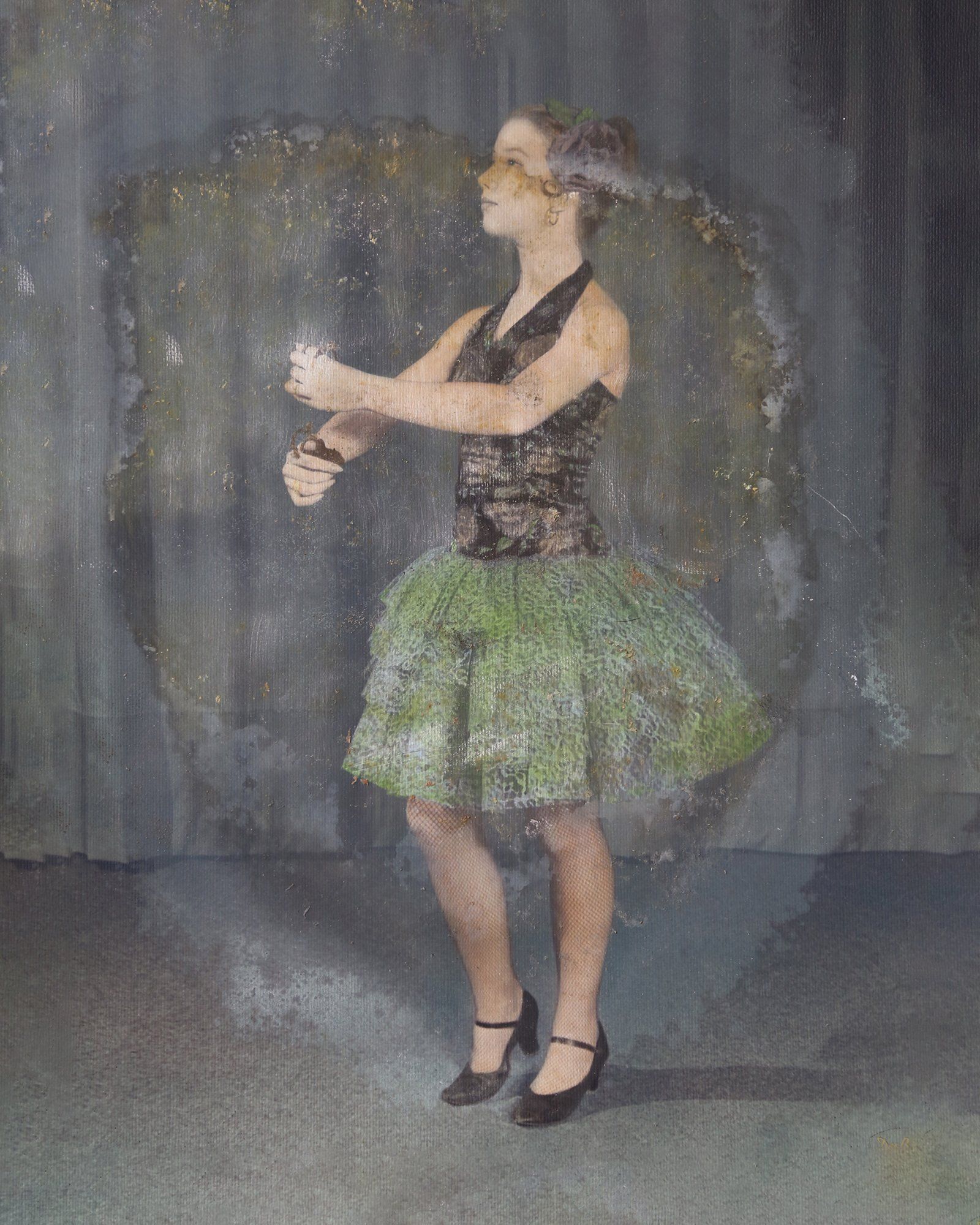 A woman in a green dress is standing in front of a mirror.